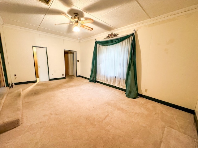 unfurnished room featuring crown molding, baseboards, and light colored carpet