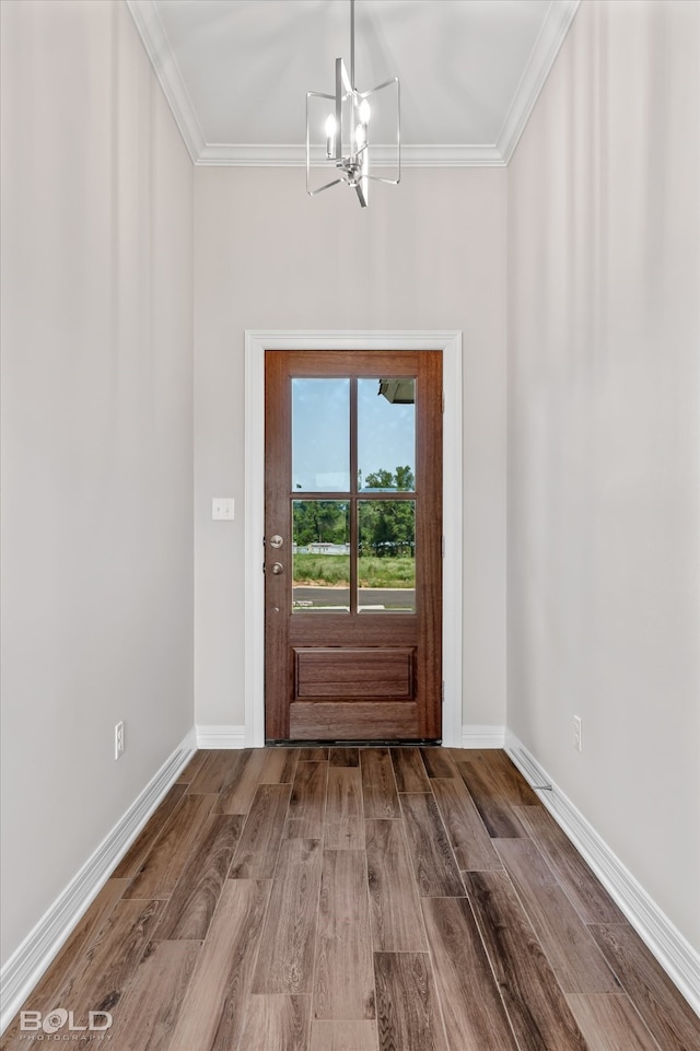 entryway featuring ornamental molding, hardwood / wood-style floors, and an inviting chandelier