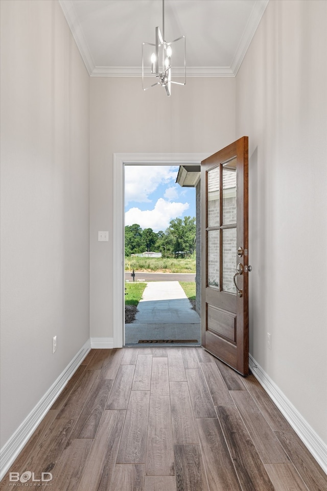 entryway featuring hardwood / wood-style floors, crown molding, and a notable chandelier