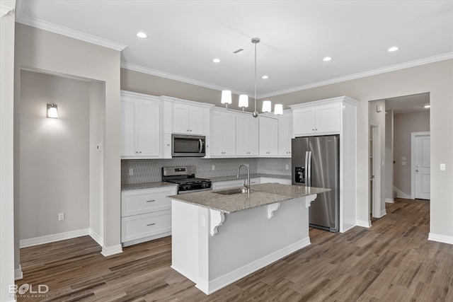 kitchen with tasteful backsplash, appliances with stainless steel finishes, sink, white cabinets, and hardwood / wood-style floors