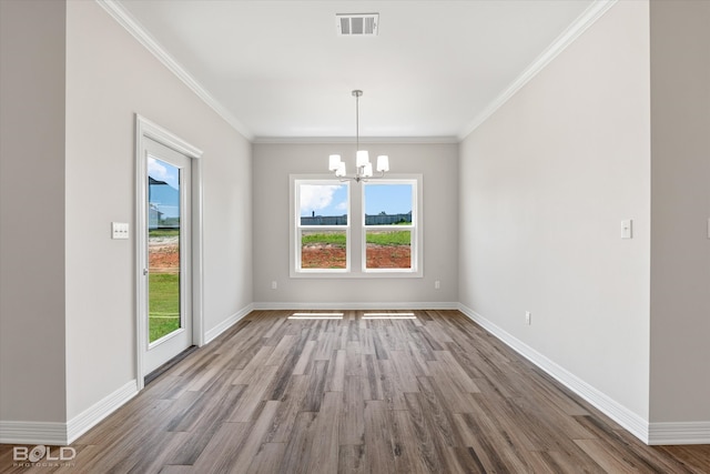 unfurnished dining area with wood-type flooring, a chandelier, a healthy amount of sunlight, and crown molding