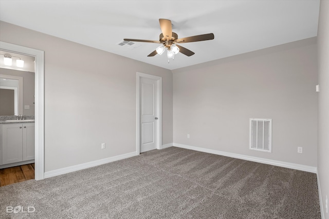 unfurnished bedroom featuring ceiling fan, sink, carpet flooring, and ensuite bathroom