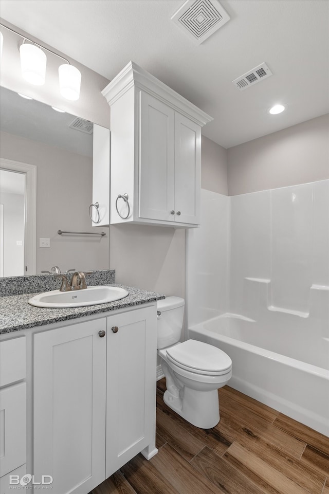 full bathroom featuring vanity, toilet, shower / tub combination, and hardwood / wood-style flooring