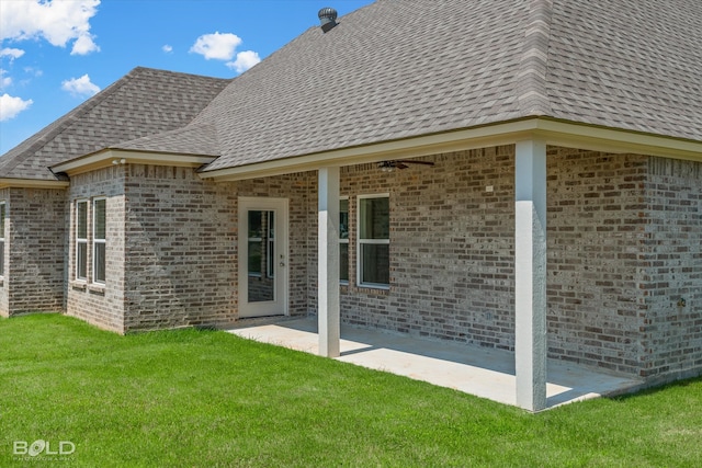 rear view of property with ceiling fan, a patio area, and a yard