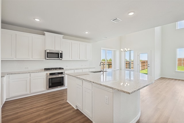 kitchen featuring appliances with stainless steel finishes, sink, light wood-type flooring, and white cabinets