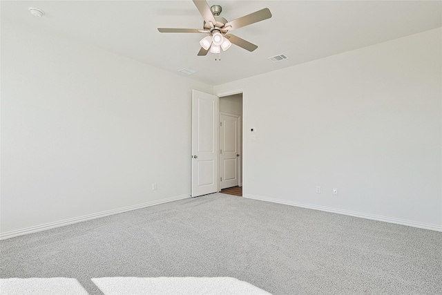 unfurnished room featuring light carpet, baseboards, visible vents, and a ceiling fan