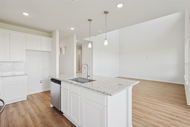 kitchen with dishwasher, an island with sink, and white cabinets