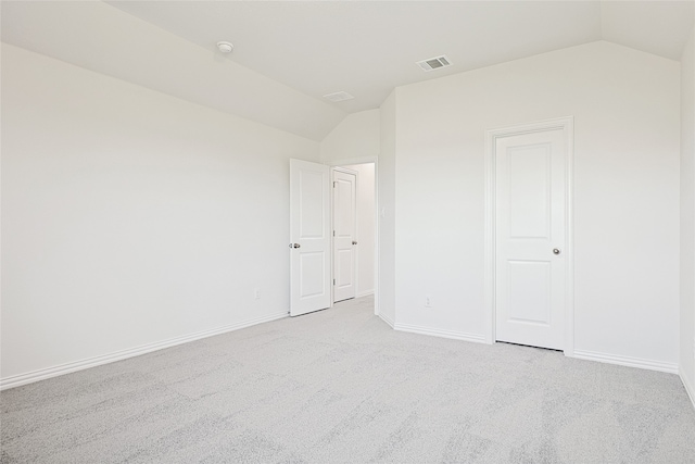 carpeted empty room featuring lofted ceiling