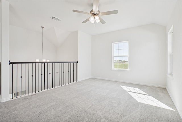 empty room with lofted ceiling, visible vents, light carpet, ceiling fan, and baseboards