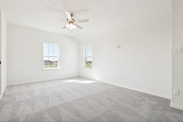 spare room with ceiling fan, baseboards, lofted ceiling, and light colored carpet