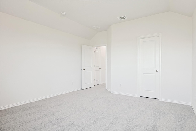 unfurnished bedroom featuring lofted ceiling, baseboards, light carpet, and visible vents