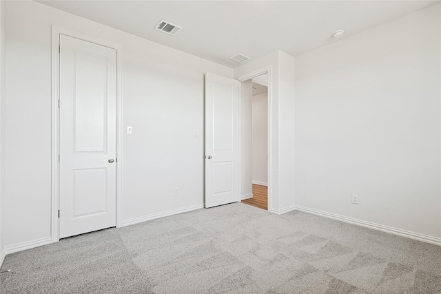 unfurnished bedroom with baseboards, visible vents, and light colored carpet