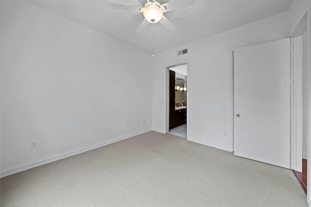 unfurnished bedroom with visible vents, ensuite bathroom, a ceiling fan, light carpet, and baseboards