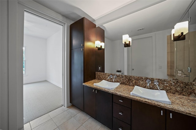 bathroom featuring double vanity, tile patterned flooring, visible vents, and a sink