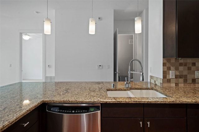 kitchen featuring stainless steel dishwasher, a sink, light stone countertops, and pendant lighting