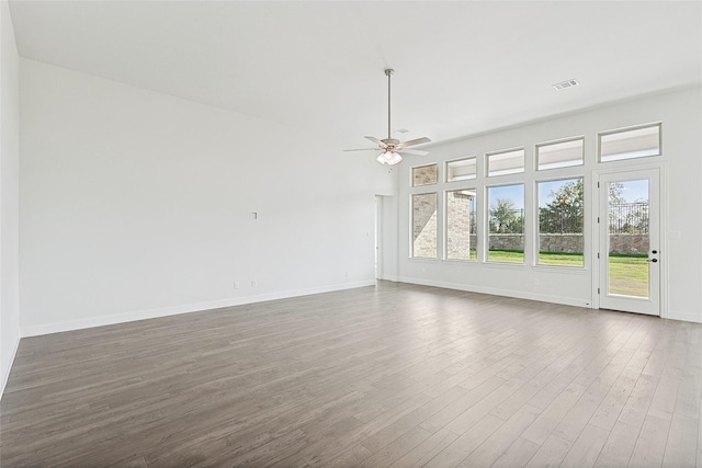 unfurnished living room featuring ceiling fan, dark wood-type flooring, visible vents, and baseboards