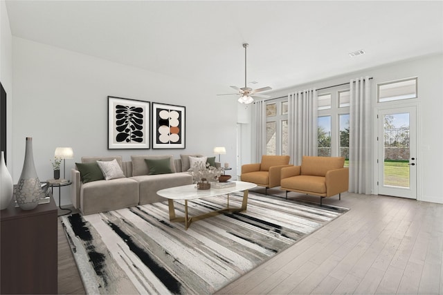 living room with ceiling fan, wood finished floors, and visible vents