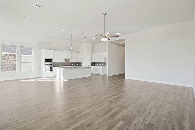 unfurnished living room with recessed lighting, visible vents, baseboards, a ceiling fan, and light wood-type flooring