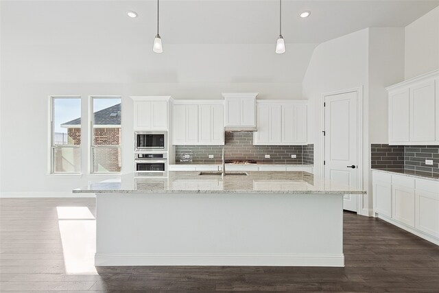 kitchen with stainless steel oven, a sink, built in microwave, and pendant lighting