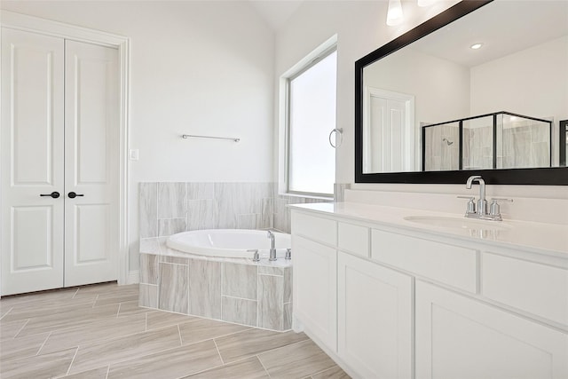 bathroom with a bath, a stall shower, a closet, and vanity