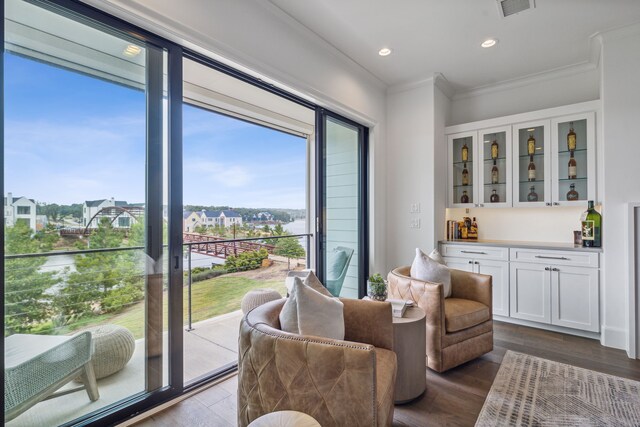 living area with wood-type flooring and crown molding