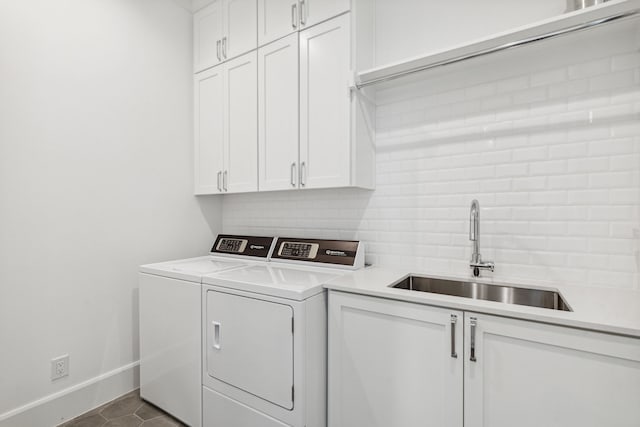 laundry area featuring cabinets, separate washer and dryer, sink, and light tile patterned floors