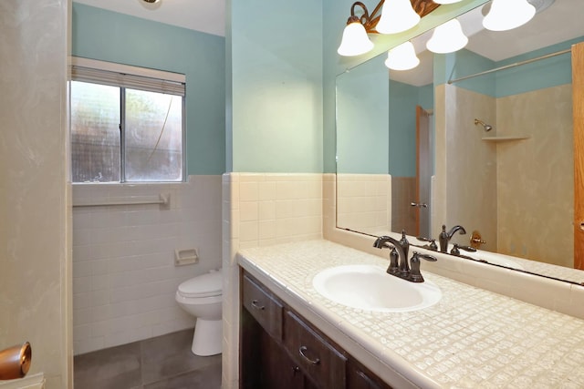 bathroom featuring tile walls, tile patterned flooring, vanity, walk in shower, and toilet