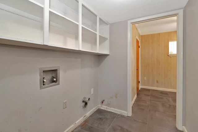 clothes washing area featuring hookup for a washing machine, hookup for a gas dryer, wooden walls, and dark tile patterned floors