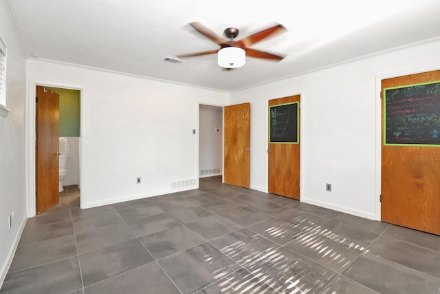 tiled spare room featuring ornamental molding and ceiling fan