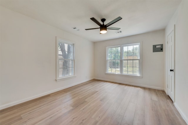 spare room with light hardwood / wood-style floors, electric panel, and ceiling fan