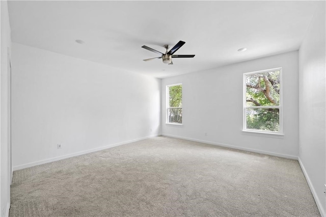 carpeted spare room with ceiling fan