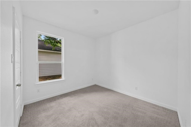 spare room featuring light colored carpet