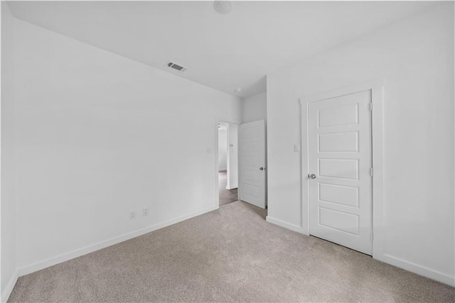 unfurnished bedroom featuring light carpet and a closet