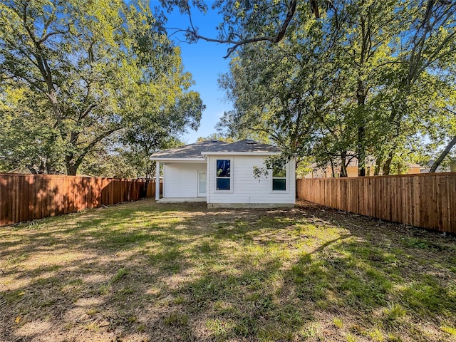 back of house with a lawn