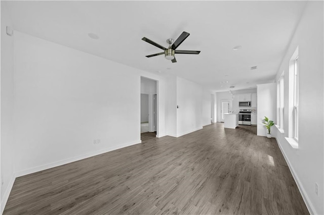 unfurnished living room featuring ceiling fan and dark hardwood / wood-style flooring