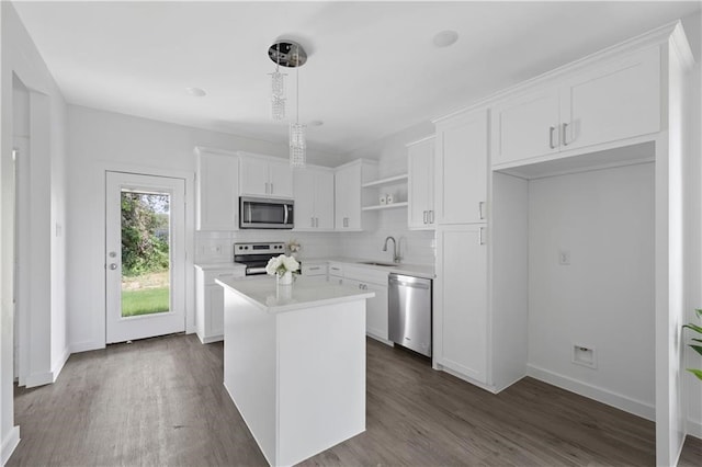 kitchen featuring white cabinetry, a center island, sink, and stainless steel appliances