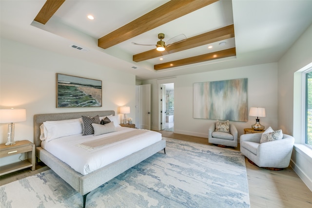 bedroom with light hardwood / wood-style floors, ceiling fan, beamed ceiling, and a raised ceiling