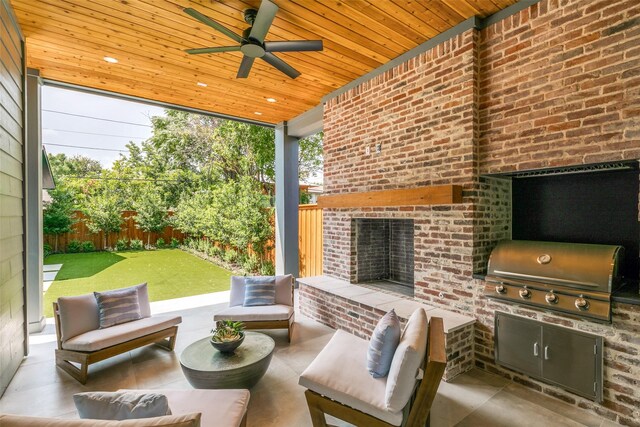 view of patio with an outdoor brick fireplace, grilling area, exterior kitchen, and ceiling fan