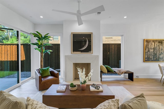 living room featuring ceiling fan and light hardwood / wood-style flooring