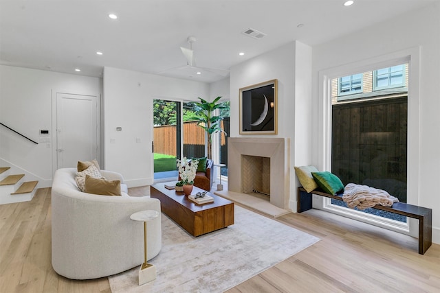 living room featuring ceiling fan, light hardwood / wood-style flooring, and a healthy amount of sunlight