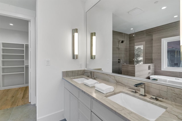 bathroom with plenty of natural light, separate shower and tub, hardwood / wood-style floors, and dual bowl vanity