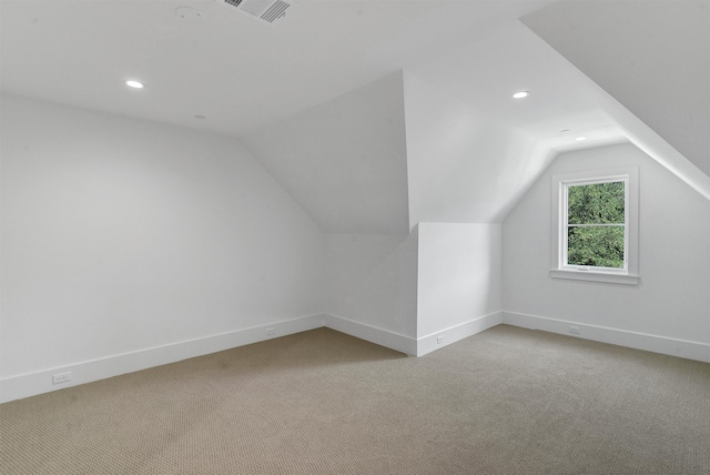 bonus room with lofted ceiling and light colored carpet