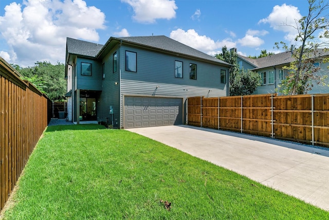 back of property featuring a lawn and a garage