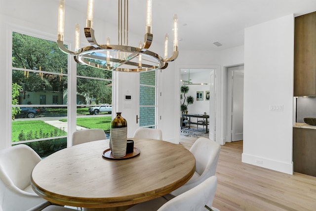 dining space featuring light hardwood / wood-style flooring and an inviting chandelier