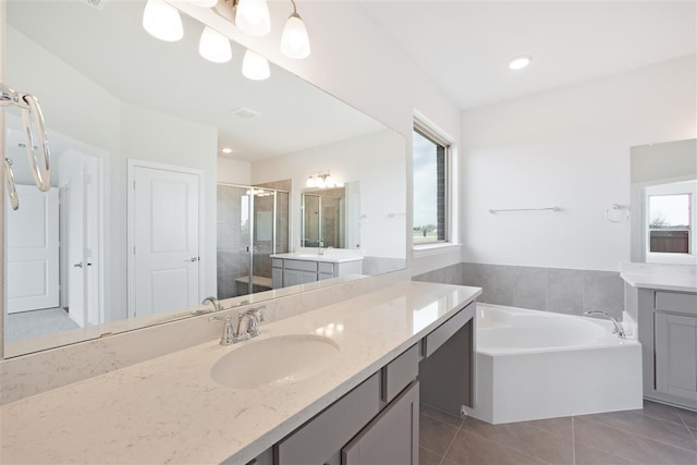 bathroom featuring plus walk in shower, vanity, and tile patterned flooring