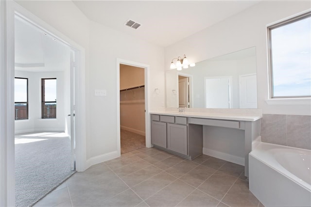 bathroom featuring tile patterned flooring, a tub, and vanity