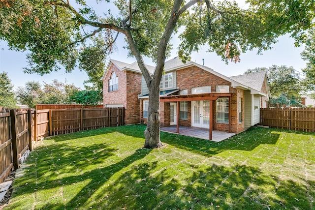 rear view of property with a yard and a patio