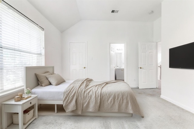 bedroom featuring connected bathroom, light colored carpet, and vaulted ceiling