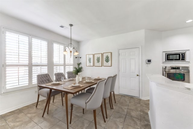 dining area with light tile patterned floors and a chandelier