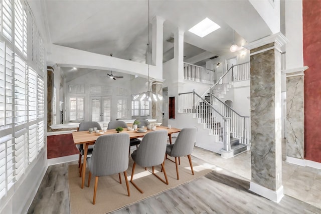 dining room with ornate columns, ceiling fan, high vaulted ceiling, and hardwood / wood-style flooring